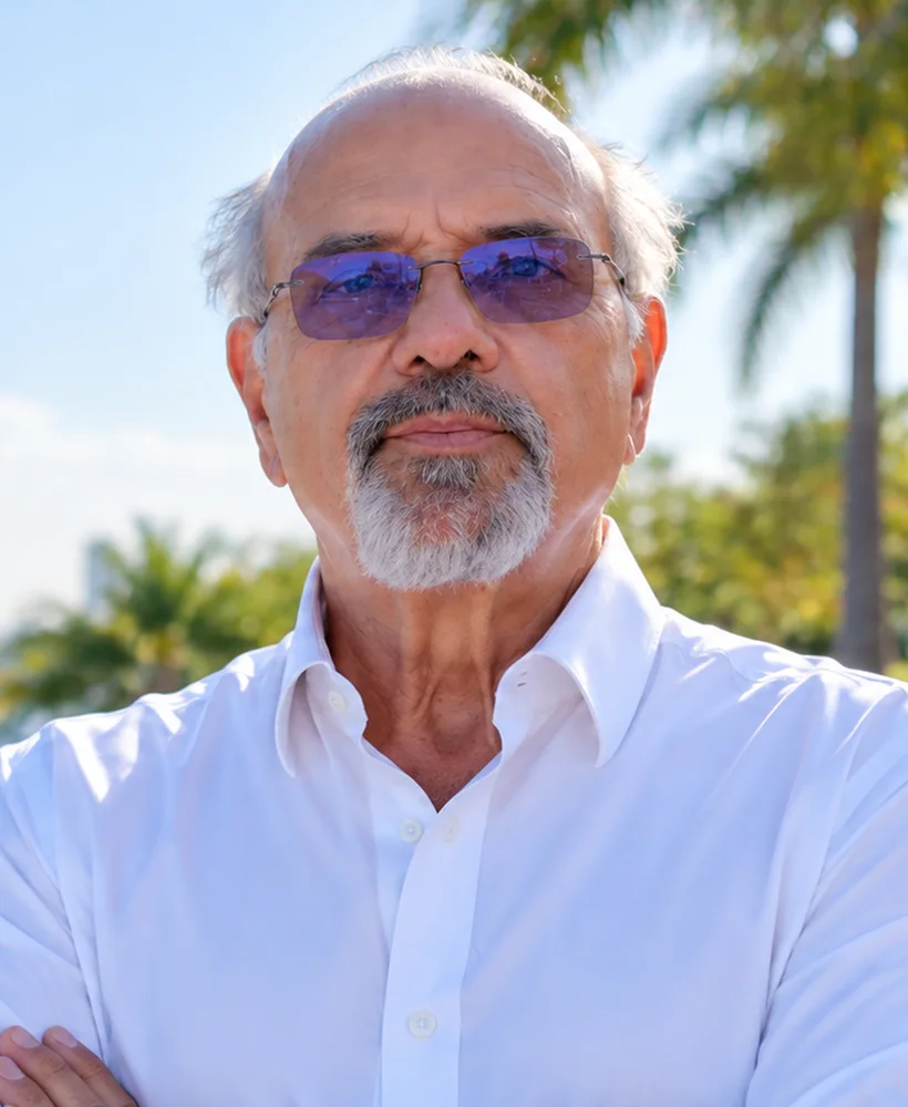 Portrait of Alex Lukianov wearing a white shirt and tinted glasses